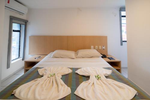um quarto com uma cama com duas almofadas em Lagoa Park Hotel em João Pessoa