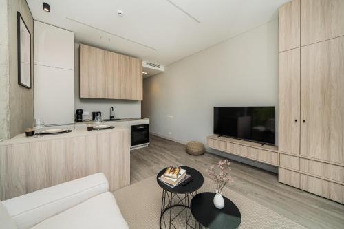 a kitchen and living room with a couch and a table at Kaunorama Riverside Suite in Kaunas