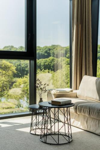 a living room with a couch and a table in front of a window at Kaunorama Riverside Suite, Business & Relax Stay in Kaunas