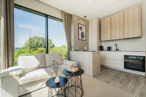 een woonkamer met een bank en een tafel bij Kaunorama Riverside Suite in Kaunas