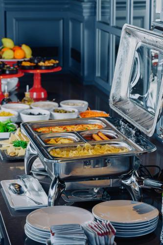 a buffet with a tray of food on a table at Tapis Rouge Design Boutique Hotel in Batumi
