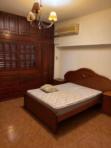 ein Schlafzimmer mit einem Bett und Holzschränken in der Unterkunft La Rosa in Santiago del Estero