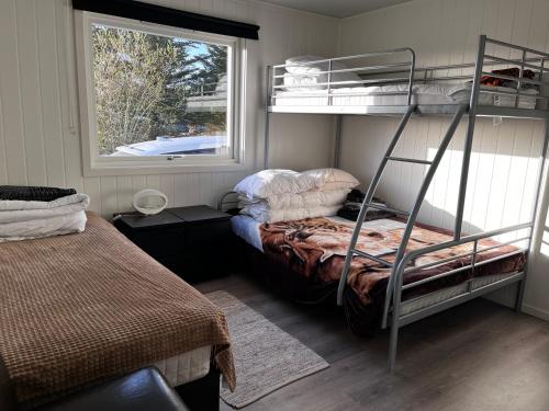 a bedroom with two bunk beds and a window at Feriehus nær sjøen på Kvenvær in Hitra