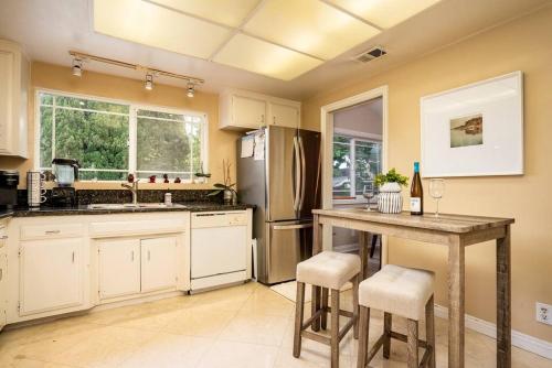 a kitchen with a table and a refrigerator at Coastal Family House! OC in Westminster