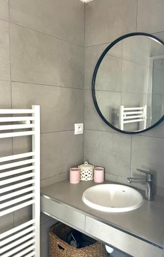 une salle de bain avec un lavabo et un miroir dans l'établissement Charmant T3 5 min de porticcio, à Porticcio