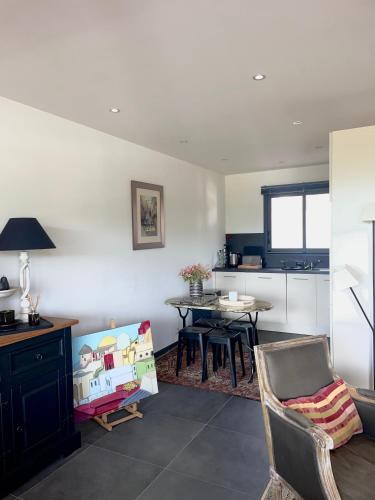 une cuisine avec une table et des chaises dans une pièce dans l'établissement Charmant T3 5 min de porticcio, à Porticcio