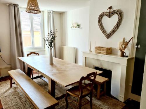 une salle à manger avec une table et une cheminée dans l'établissement Grand duplex au coeur du centre historique, à Paray-le-Monial