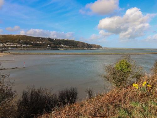 a view of a body of water with a hill at Harbour High Annex in Fishguard