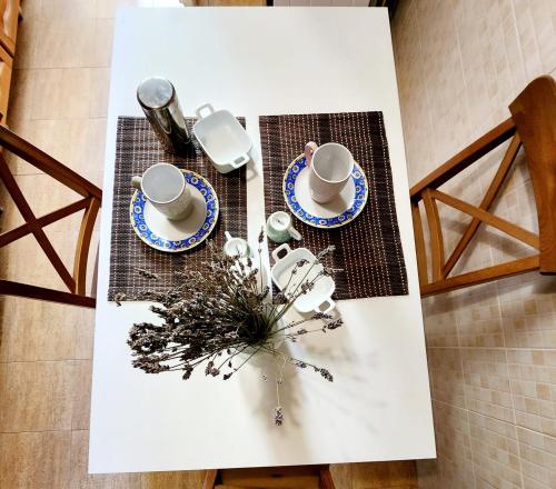 a table with two cups and plates on it at Appartamento comodo e accogliente a Ciampino in Ciampino