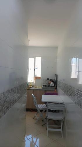 a white room with a table and chairs and a desk at nour 2 in Skhirat