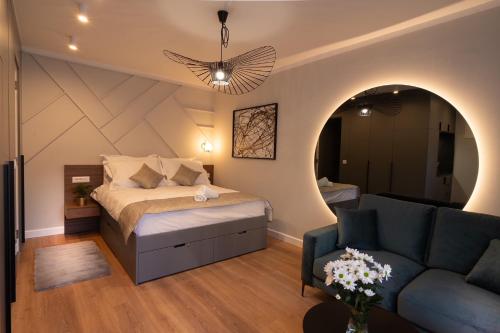 een slaapkamer met een bed en een bank bij Apartments and More in Zagreb