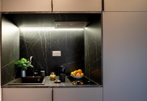 een keuken met een spoelbak en een schaal fruit bij Apartments and More in Zagreb