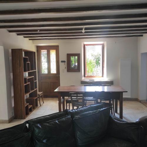 un salon avec une table et des chaises en bois dans l'établissement MAISON DE CHARME LAC AIGUEBELETTE, à Nances