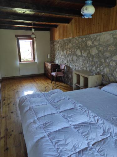 une chambre avec un grand lit et un bureau dans l'établissement MAISON DE CHARME LAC AIGUEBELETTE, à Nances