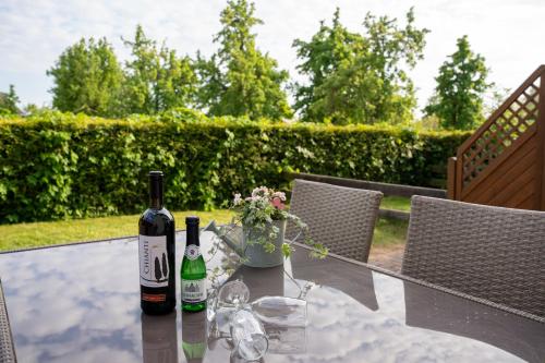 duas garrafas de vinho sentadas numa mesa de vidro em Ferienhof Kruse Wohnung Nr 7 em Grömitz