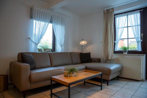 uma sala de estar com um sofá e uma mesa em Ferienhof Kruse Wohnung Nr 7 em Grömitz