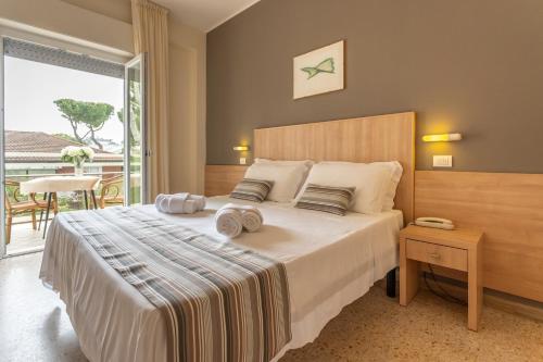 sypialnia z dużym łóżkiem i balkonem w obiekcie Hotel Cormoran Riccione w mieście Riccione