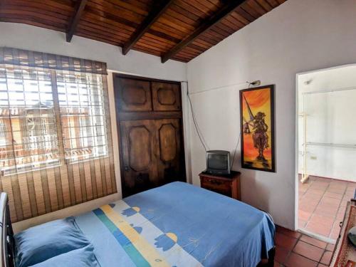 a bedroom with a bed and a tv in it at Casa Acogedora y Encantadora in San Cristóbal