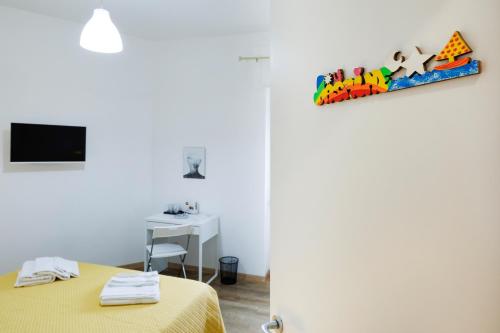 a bedroom with a yellow bed and a desk at La Fenice Suites Sardinia in Quartu SantʼElena