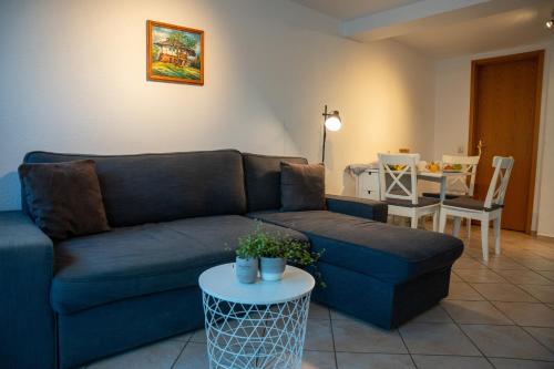 a living room with a blue couch and a table at Ferienhof Kruse Wohnung 9 in Grömitz