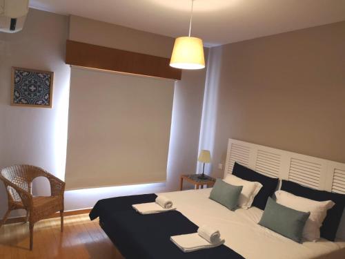 a bedroom with a large bed and a chair at Palácio Garden's House by LovelyStay in Porto