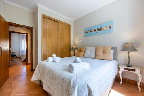 a bedroom with a large white bed with towels on it at CoolHouses Algarve, Casa das Amendoeiras, V4 Praia da Luz in Luz