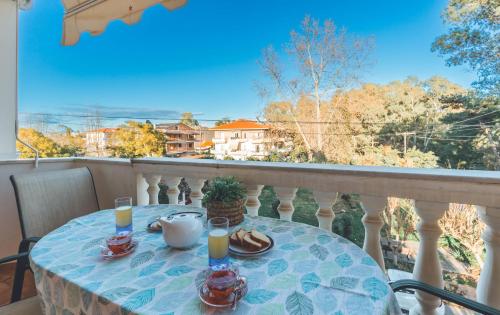 a table with two glasses of orange juice on a balcony at Saint George Apartment in Preveza