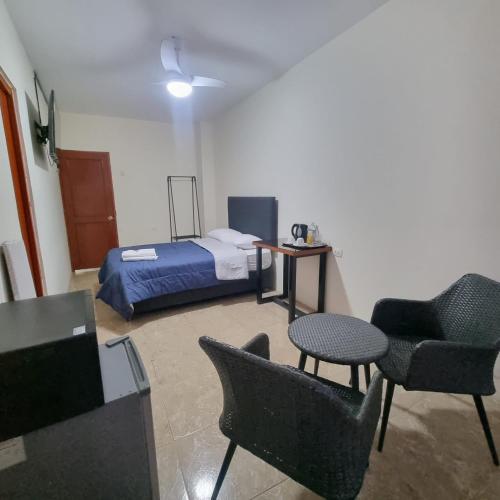 a room with a bed and a table and chairs at Gran Imperial Avenida in Tumbes