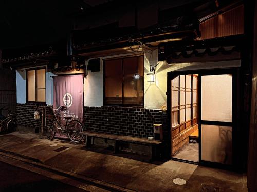 京都市にあるホステルオトロムンドのベンチ付きの部屋、建物の隣に自転車が備わる部屋