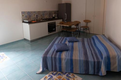 a bedroom with a bed and a kitchen with a table at PALAZZO PELLEGRINO vietri in Vietri sul Mare