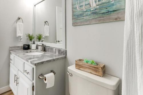 a bathroom with a sink and a toilet with a mirror at Beaver Lake Retreat with Deck Paddle, Bike, Relax! in Springdale