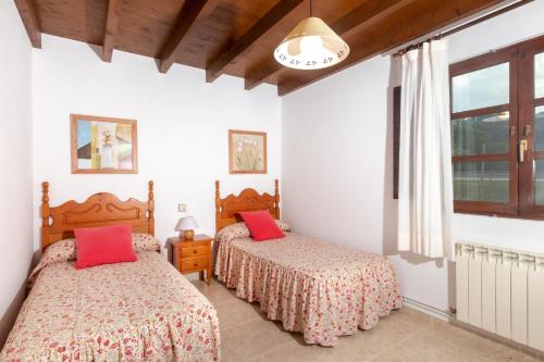 um quarto com 2 camas e uma janela em Apartamentos el Acebo em Naves