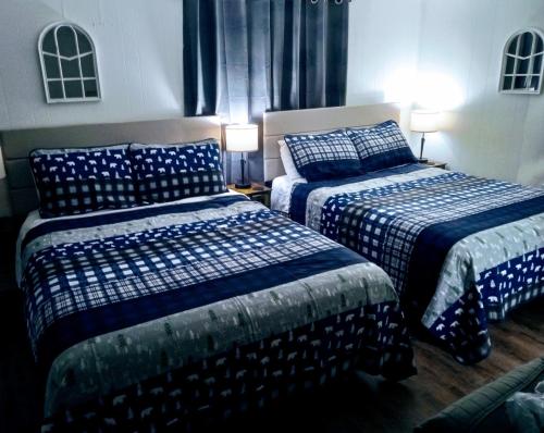 a bedroom with two beds with blue and white sheets at The Evening Shade River Lodge and Cabins in Chimney Rock
