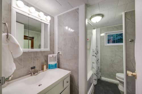 La salle de bains est pourvue d'un lavabo, de toilettes et d'un miroir. dans l'établissement Kentucky Mtn Home on 80 Acres with Hot Tub and Trails!, 