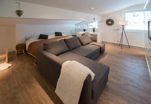 a living room with a couch and a bed at Apartmenthaus Mountainvista in Kleinarl