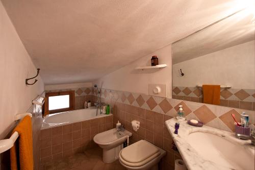 a bathroom with a sink and a toilet and a tub at Fisherman's House in Riomaggiore