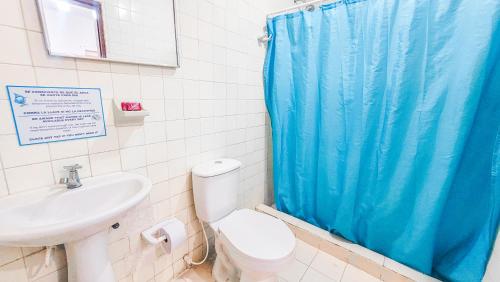 a bathroom with a blue shower curtain and a sink at Hotel Casa Telma in Santa Marta