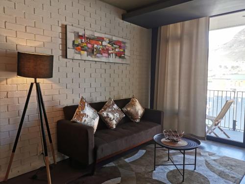 sala de estar con sofá y almohadas en Modern Apartments en Ciudad del Cabo