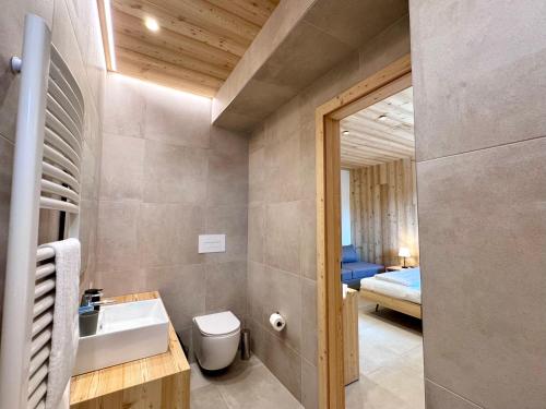 een badkamer met een wastafel en een toilet en een slaapkamer bij Villa Ginevra Resort Agrituristico in Ficarra