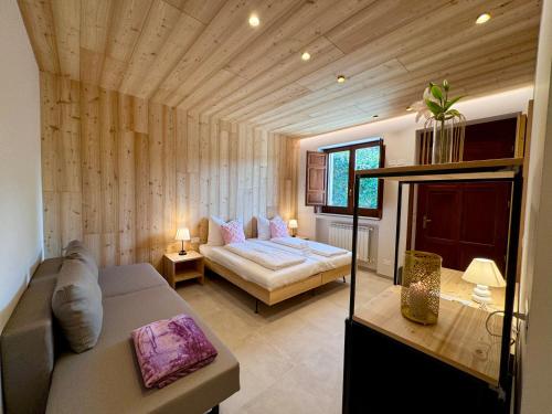 Villa Ginevra Resort Agrituristico في Ficarra: غرفة نوم مع أريكة وسرير في غرفة