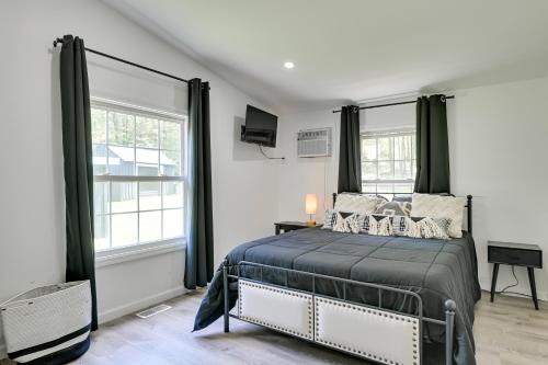 a bedroom with a bed and two windows at Catskills Family Retreat Fishing and Hiking On-Site in East Durham
