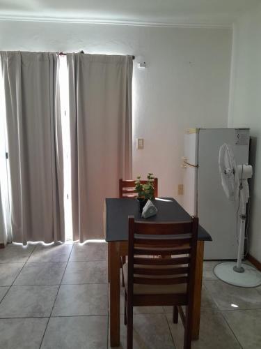 a dining room with a table and a refrigerator at Sarmiento Monoambiente in Concordia