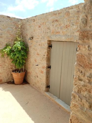 a garage with a white door and a potted plant at Oxalis Villas in Perlengiánika
