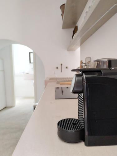 a kitchen with a black chair sitting on a counter at Oxalis Villas in Perlengiánika