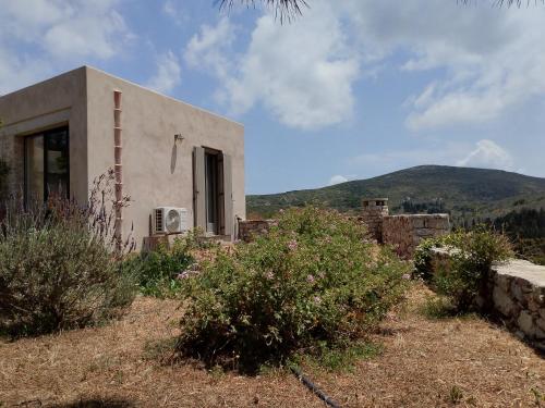 a house on a hill with mountains in the background at Oxalis Villas in Perlengiánika