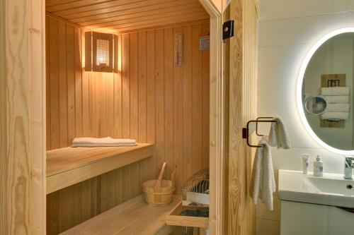 a bathroom with a sauna with a sink and a mirror at Les Eaux 207-2 Mountain adventure in Mont-Tremblant