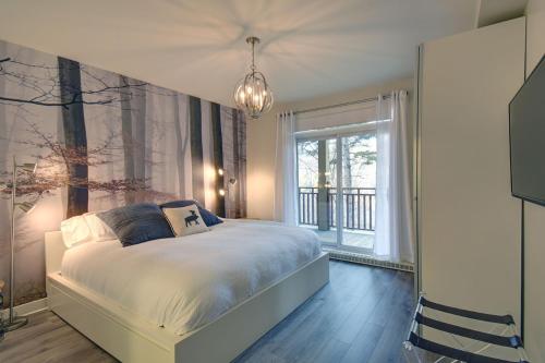 1 dormitorio con cama y ventana grande en Les Eaux 207-2 Mountain adventure en Mont-Tremblant