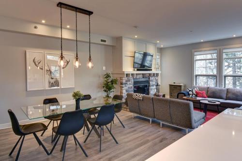 een woonkamer met een tafel, stoelen en een bank bij Tremblant Prestige - Les Eaux 207-2 in Mont-Tremblant