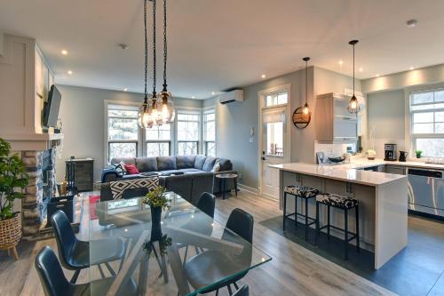 a kitchen and living room with a table and a couch at Tremblant Prestige - Les Eaux 207-2 in Mont-Tremblant