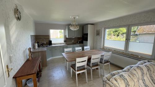 a kitchen and dining room with a wooden table and chairs at Ferienhaus Platzhirsch in Bad Hersfeld mit Garten, 2 Bäder, 3 Schlafzimmer & Küche - gratis Parkplätze in Bad Hersfeld